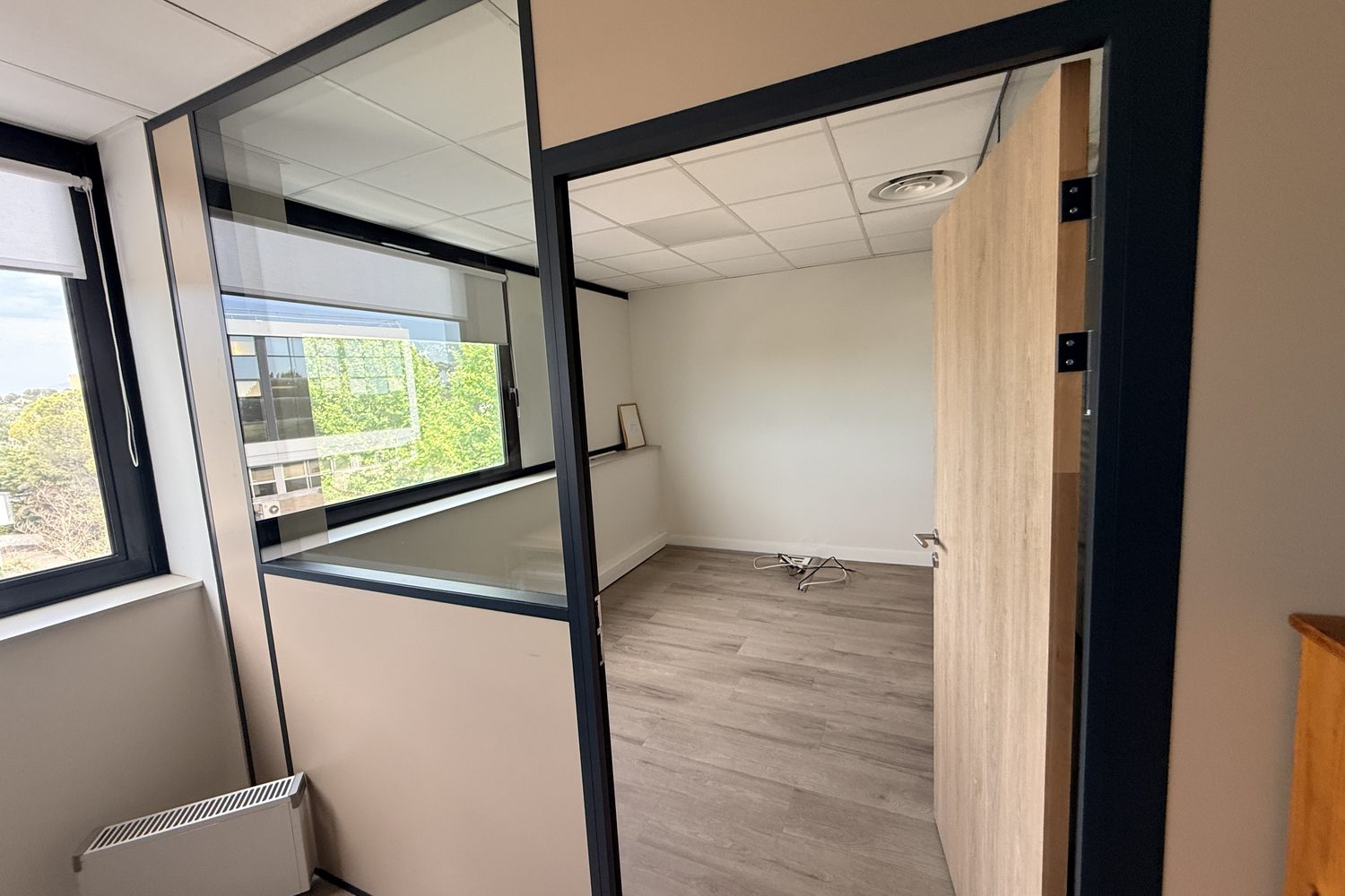 Espace B : le bureau fermé de 9,36 m², vu depuis l'open space, sa porte ouvrant sur celui-ci.