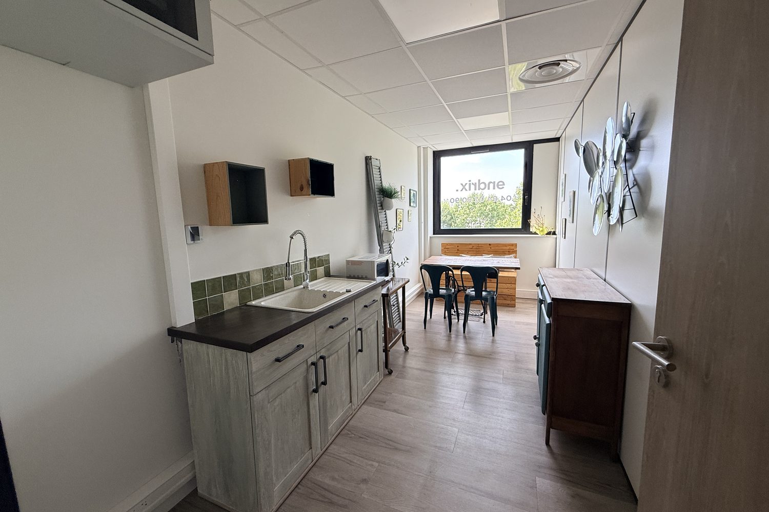 La cuisine équipée de 11,07 m², plan de travail, évier, micro-ondes et coin repas.